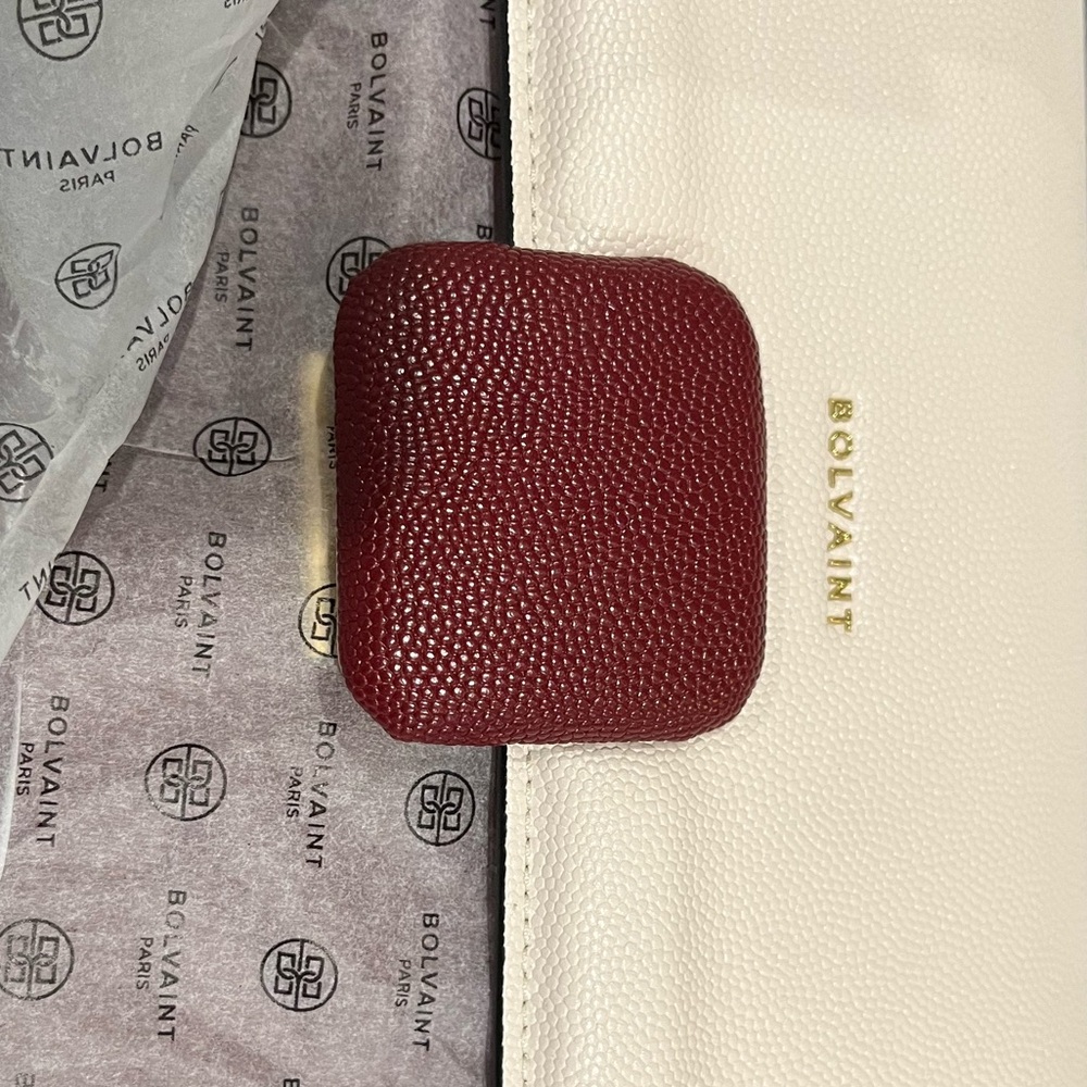A new Bolivian Paris clutch, original dust cover cream and a dark red snap.